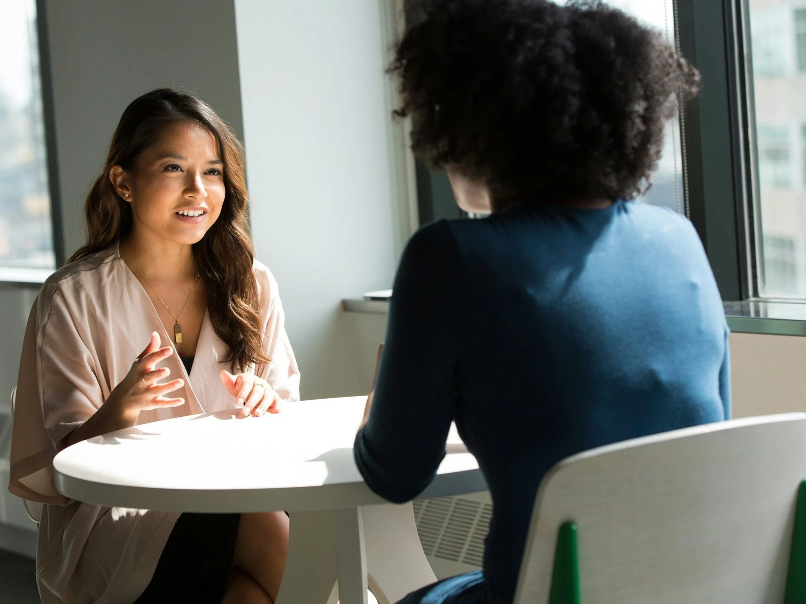 Two colleagues talking across a small round table