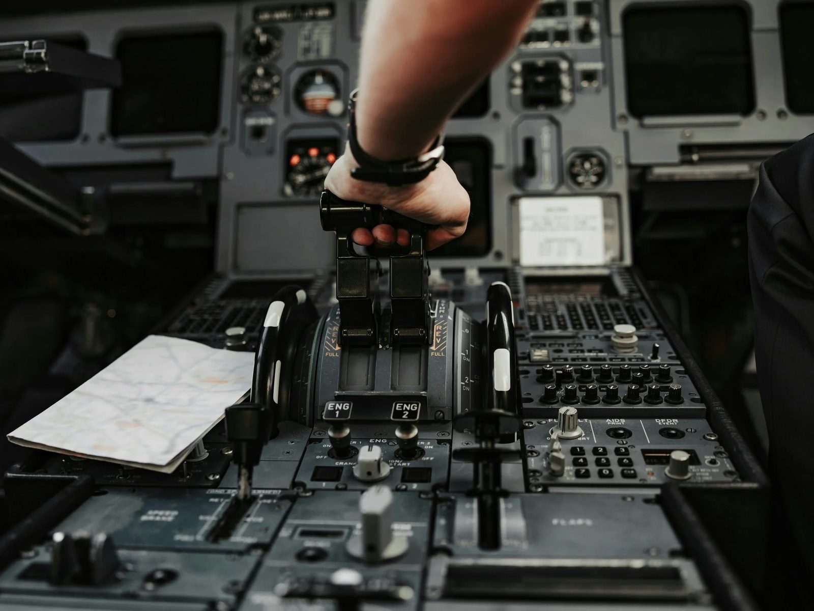 A pilot's hand on the throttle in an aircraft cockpit