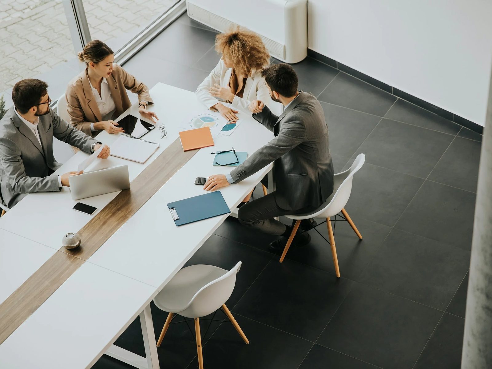 A team meeting around a white table, seen from above