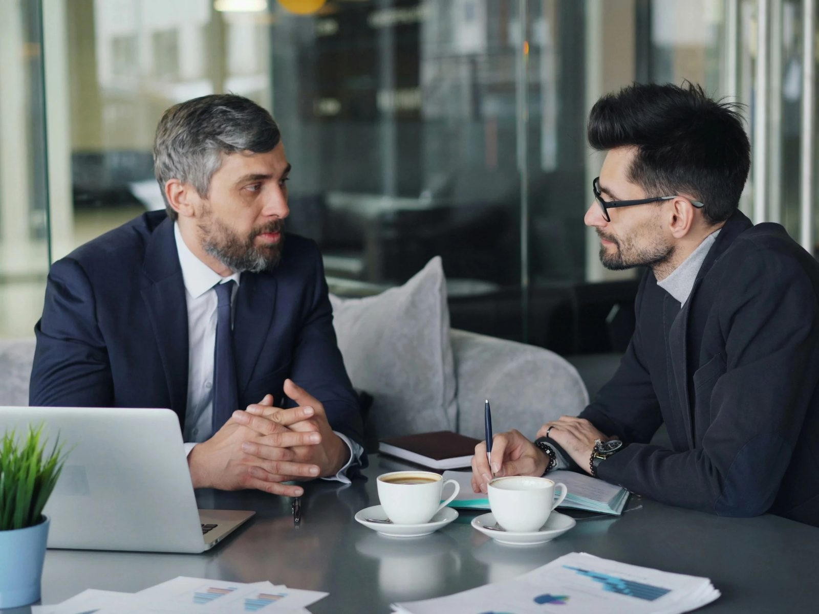 Two businessmen in conversation over coffee