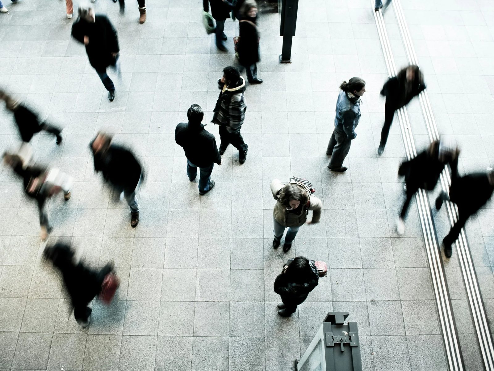 People walking across a busy lobby, seen from above