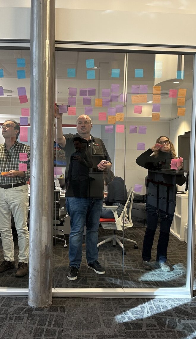 Leaders in discussion in a glass-walled meeting room