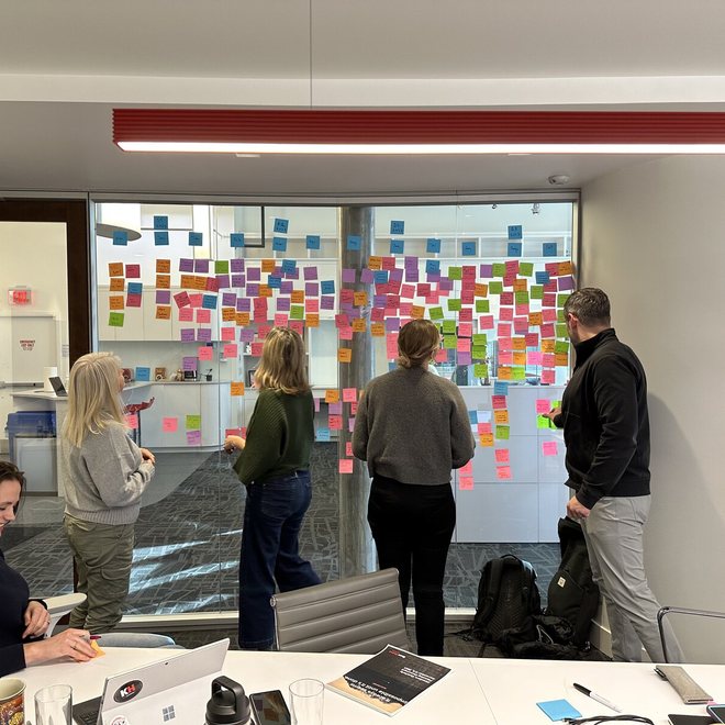 Leaders reviewing a wall of notes