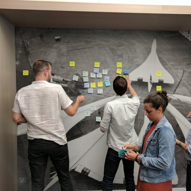 Leaders discussing notes on a wall
