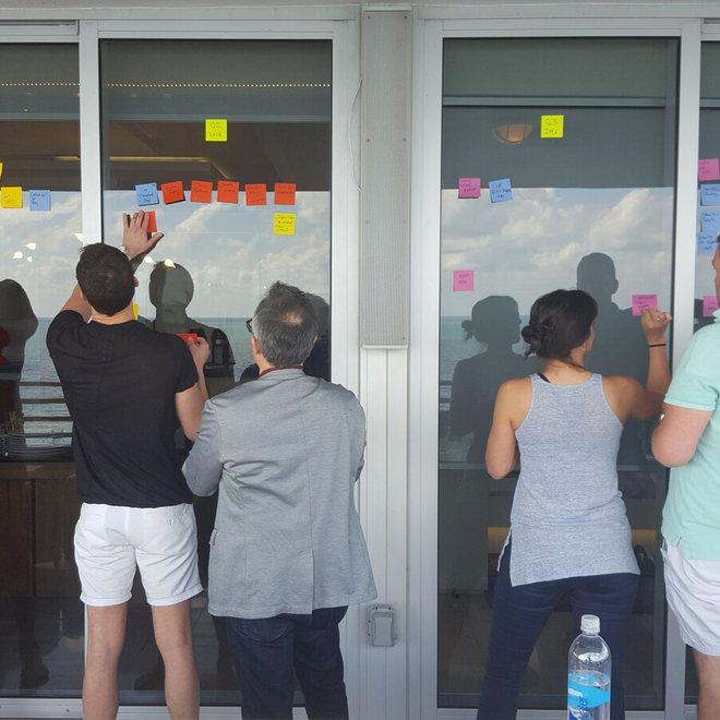 Leaders working at a window wall of notes