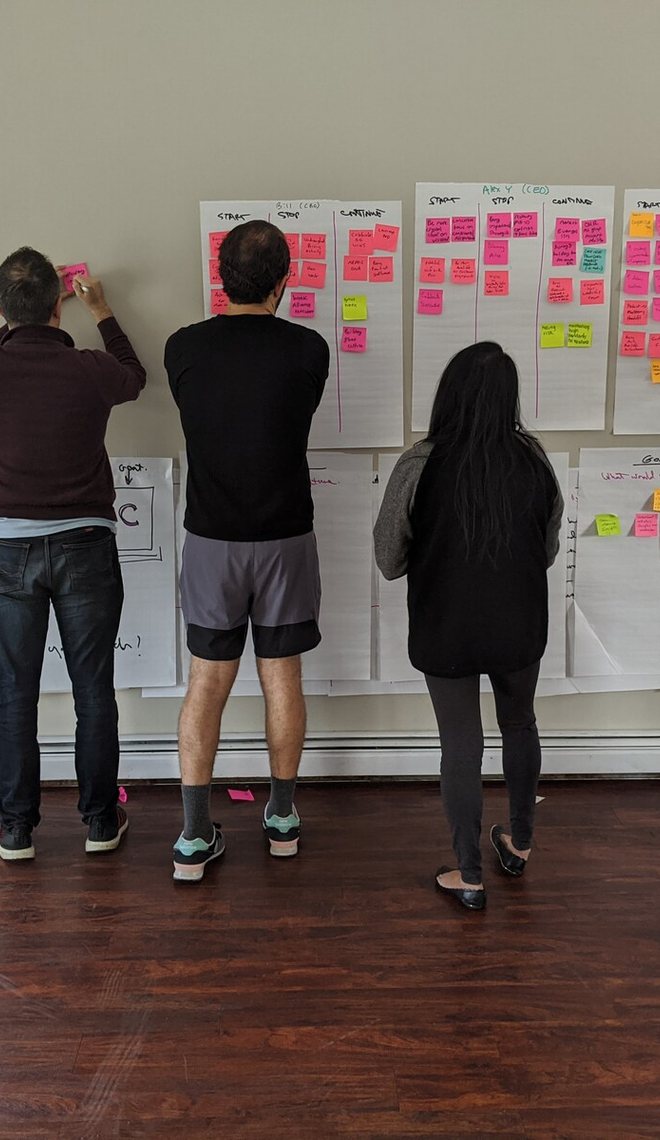 Leaders posting plans on a wall during a planning session