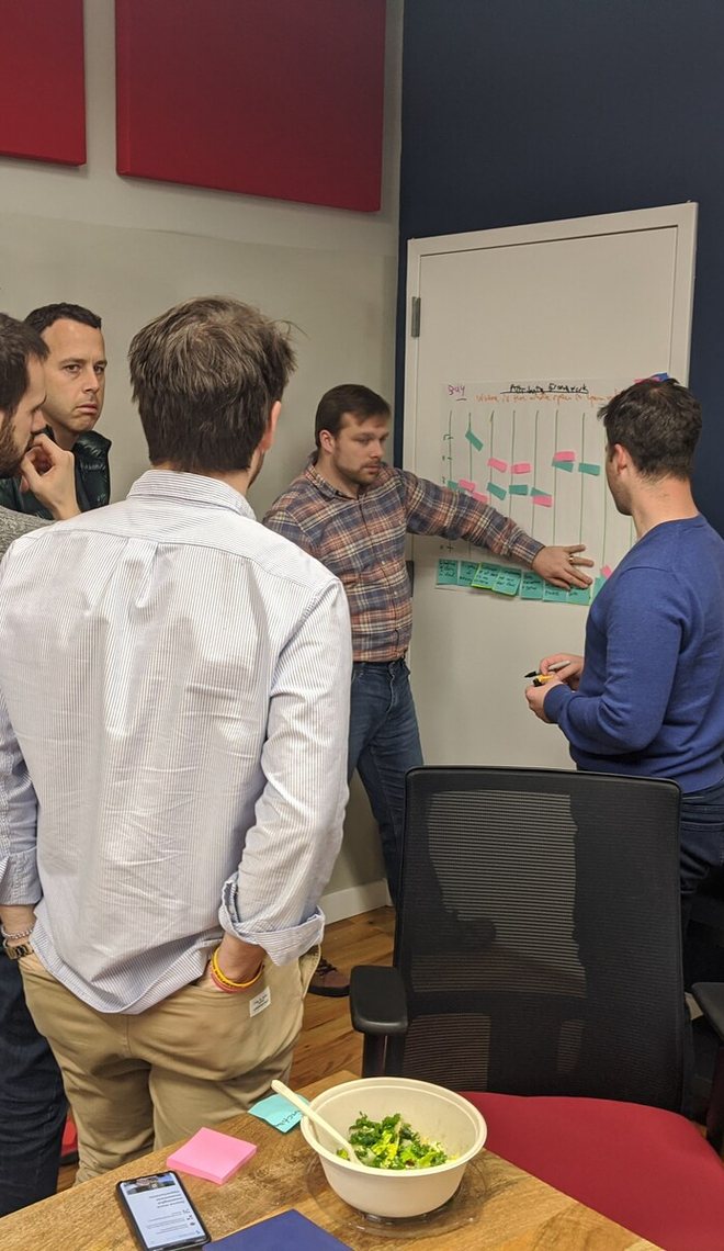 Leaders reviewing a plan on a whiteboard