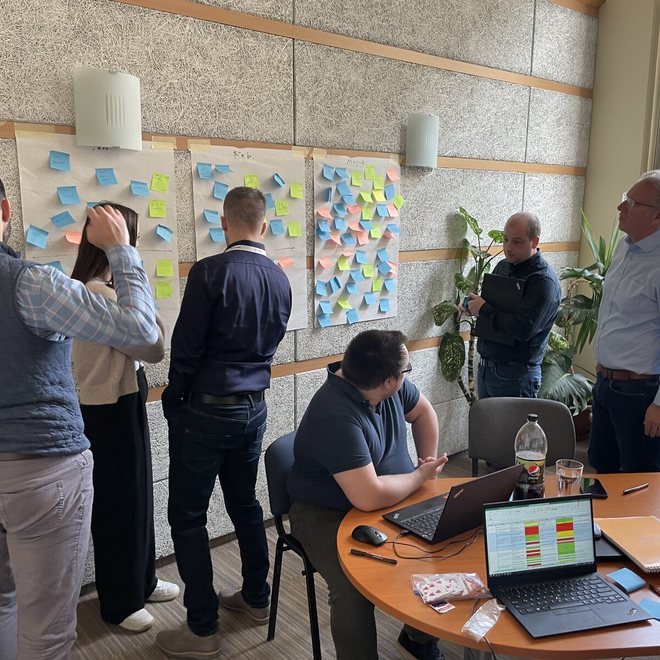 Leaders in discussion near walls of notes