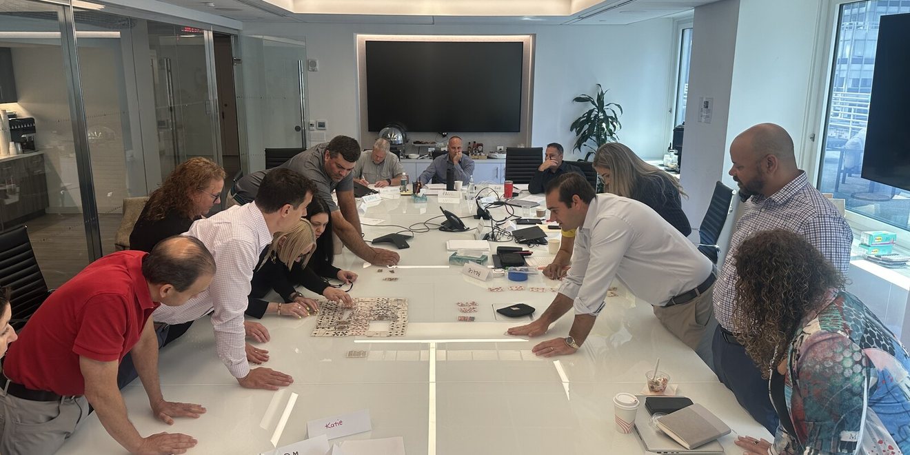 Leaders leaning over a conference table during an exercise